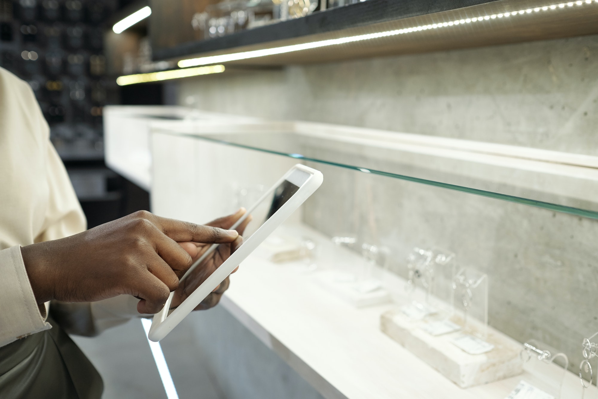 Hand of young contemporary shop assistant pointing at tablet screen